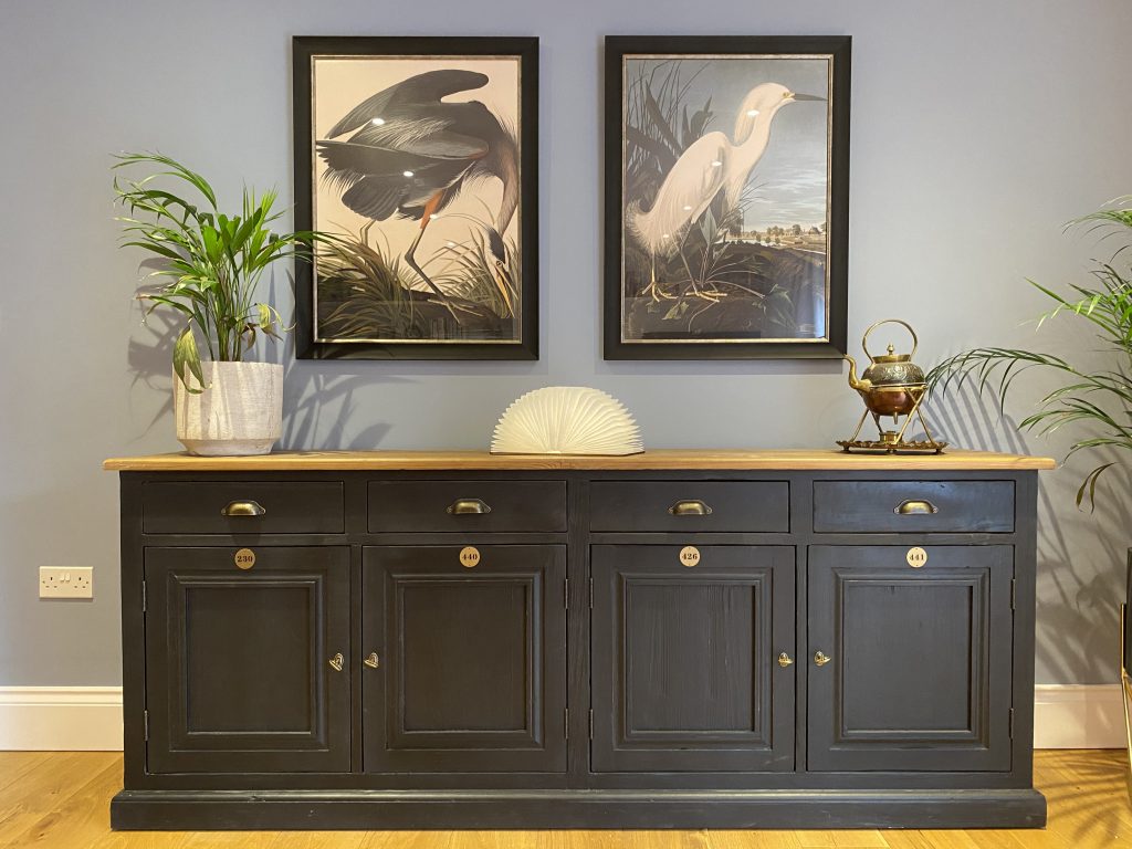 Living room with blue walls, black sideboard and large art
